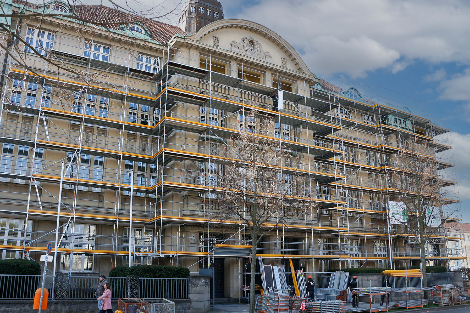 Fassadengerüst am denkmalgeschützten Verwaltungsgebäude der Konsumgenossenschaft Berlin in der Josef-Orlopp-Straße, Berlin-Lichtenberg – Frontansicht mit vollflächiger Einrüstung