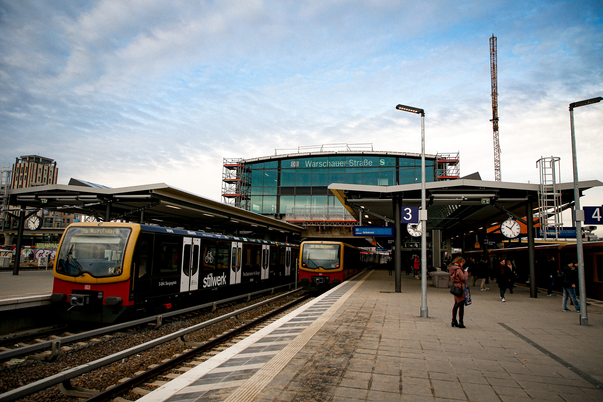 Gerüst von Ro² an der Empfangshalle des S-Bahnhofs Warschauer Straße in Berlin Friedrichshain-Kreuzberg, im Vordergrund einfahrende S-Bahnen am Bahnsteig